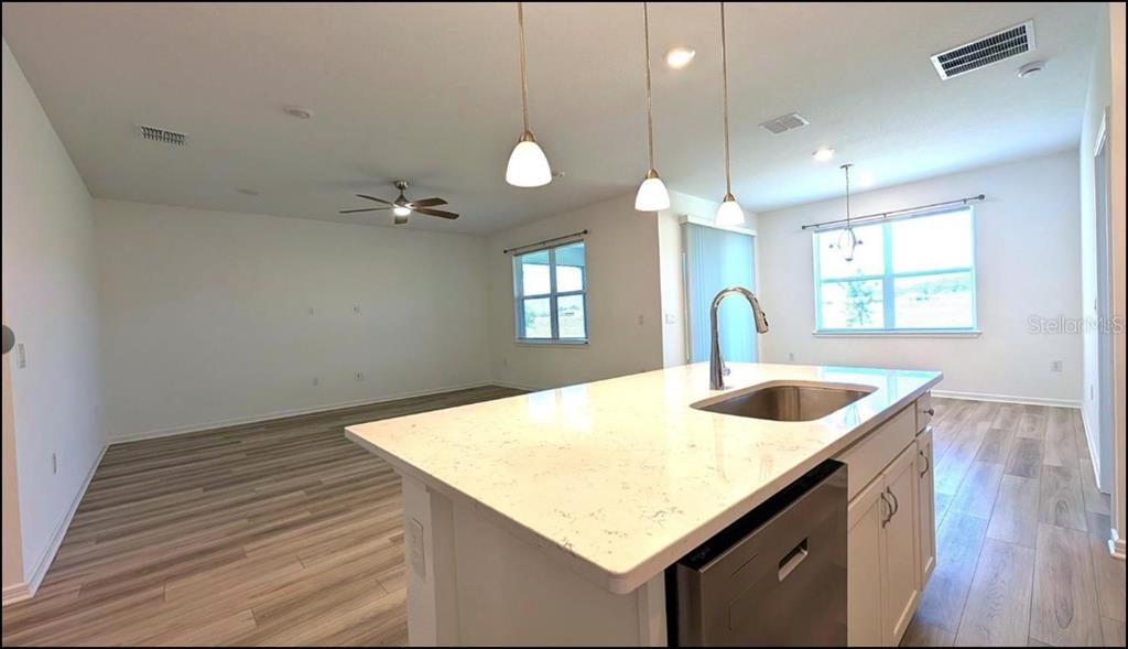 An open-concept living room and kitchen with white cabinetry, light wood flooring, and recessed lighting — 8479 SW 52ND LANE ROAD, OCALA, FL