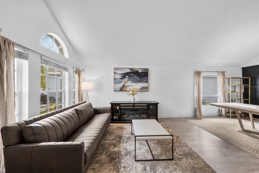 A living room features a long brown sofa, a fireplace console, and a dining area — 526 FITZWILLIAM WAY, ORLANDO, FL