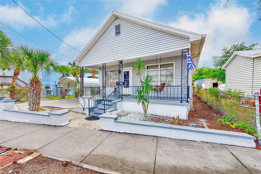 A single-story house with light gray siding, a front porch, and a low concrete wall — 632 CROSS STREET, TARPON SPRINGS, FL