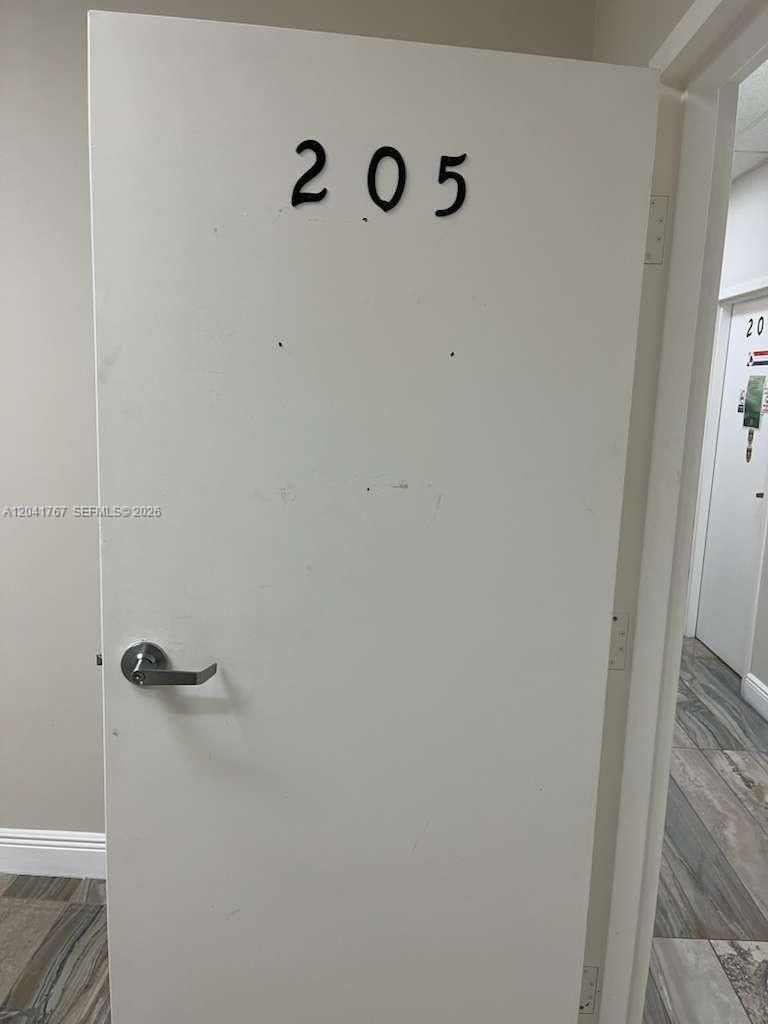 A white interior door labeled with the number 205 features a silver lever handle — 6101 W Atlantic Blvd # 205, Margate FL 33063, MARGATE, FL