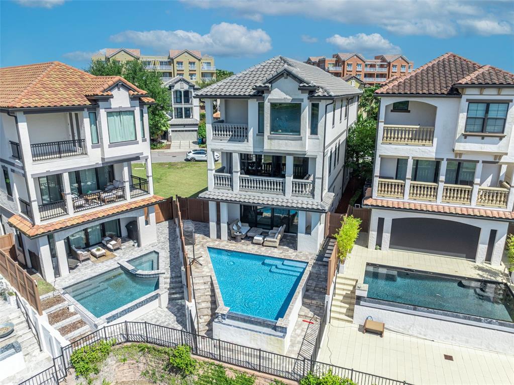 An aerial view shows three multi-story houses with private swimming pools and balconies — 7613 TOSCANA BOULEVARD, ORLANDO, FL