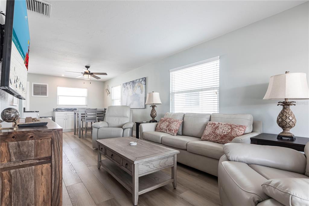 A living room features light wood flooring, a gray sofa, and a matching coffee table — 6020 MIDNIGHT PASS ROAD UNIT 35, SARASOTA, FL