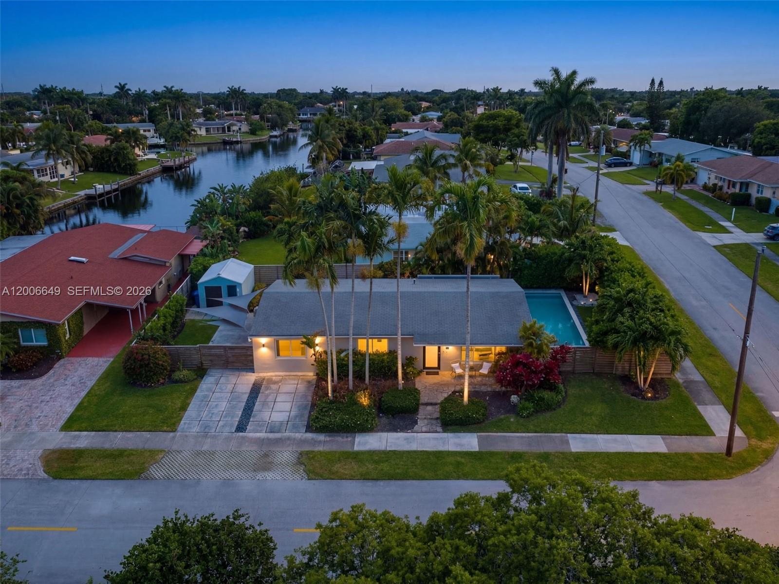 An aerial view of a single-story house with a pool, palm trees, and canal access — 930 N 11th Ct # 0, Hollywood FL 33019, HOLLYWOOD, FL