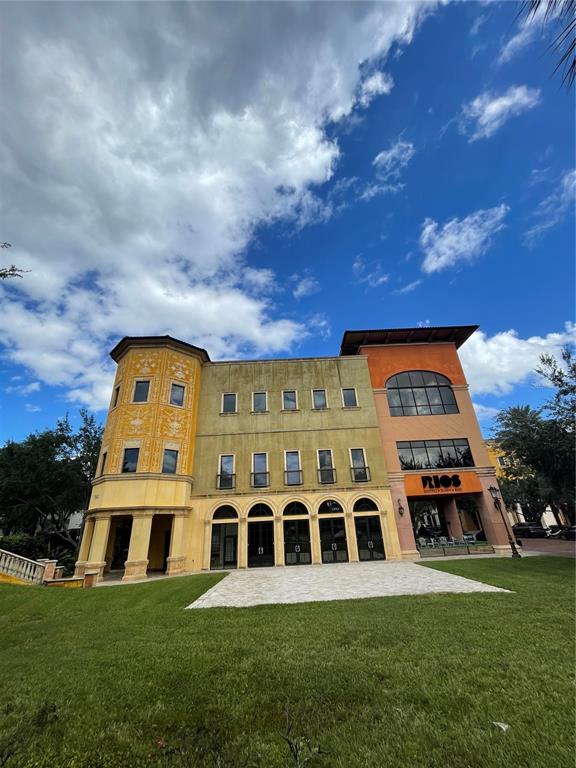 A three-story commercial building features a yellow turret, a central section, and an orange wing — 7065 WESTPOINTE BOULEVARD UNIT 303 & 304, ORLANDO, FL