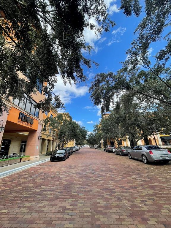 A brick-paved street lined with trees and commercial buildings under a blue sky — 7065 WESTPOINTE BOULEVARD UNIT 303 & 304, ORLANDO, FL