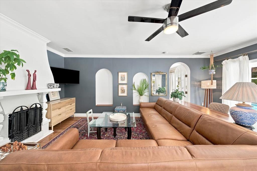 A living room features a large brown sectional sofa, a fireplace, and arched wall niches — 222 26TH AVENUE S, ST PETERSBURG, FL