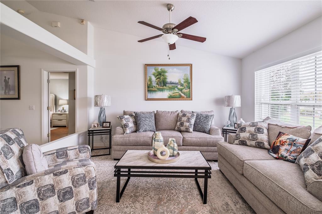 A living room features a sofa, armchairs, a coffee table, and a ceiling fan — 3501 BEAU CHENE DRIVE, KISSIMMEE, FL