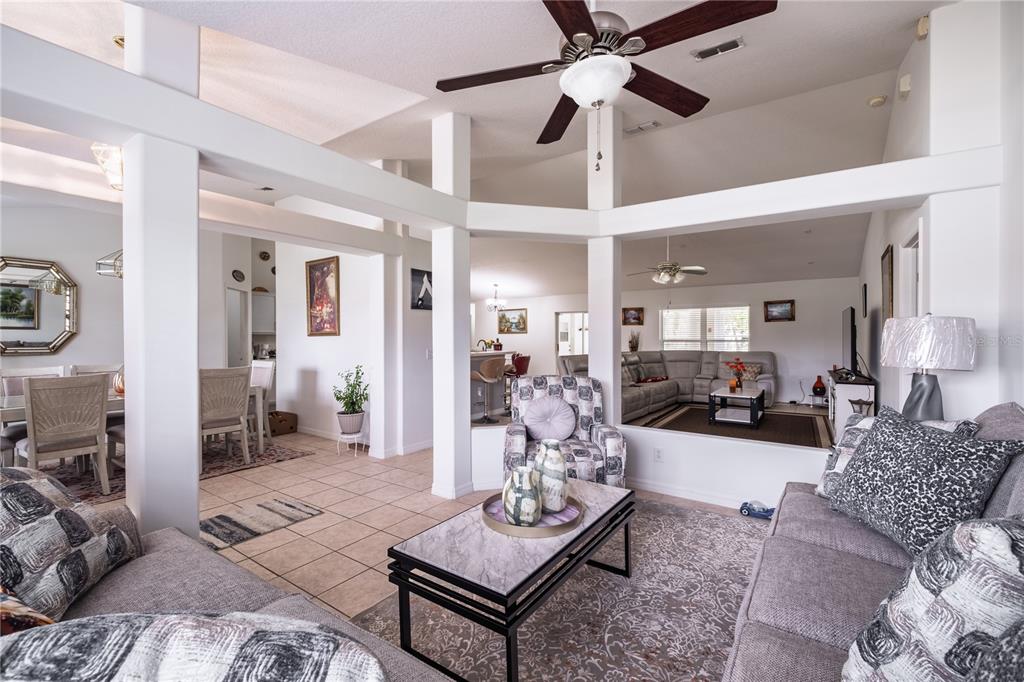 A living room with a sunken seating area, white support columns, and tile flooring — 3501 BEAU CHENE DRIVE, KISSIMMEE, FL