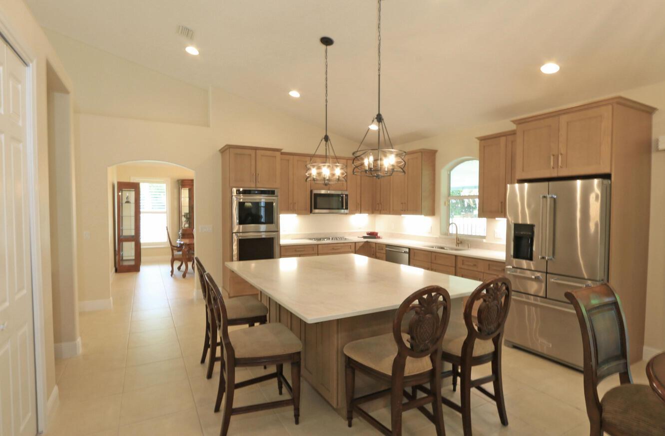A kitchen features light wood cabinets, stainless steel appliances, white countertops, and an arched window — 2879 SE Peru Street, FL 34984, FL