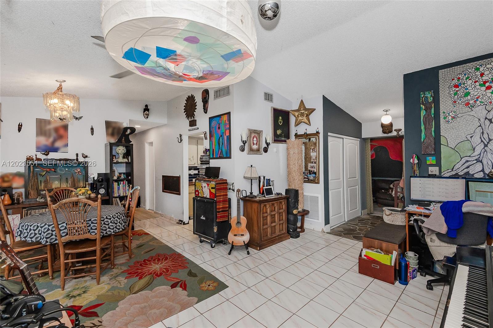 A dining area features a round table, floral rug, sliding glass doors, and dark accent wall — 11482 SW 109th Rd # 29A, Miami FL 33176, MIAMI, FL