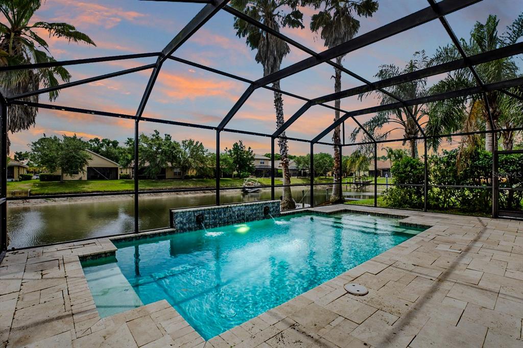 A tan stucco house with a tiled roof and a paved driveway at sunset — 18019 JAVA ISLE DRIVE, TAMPA, FL