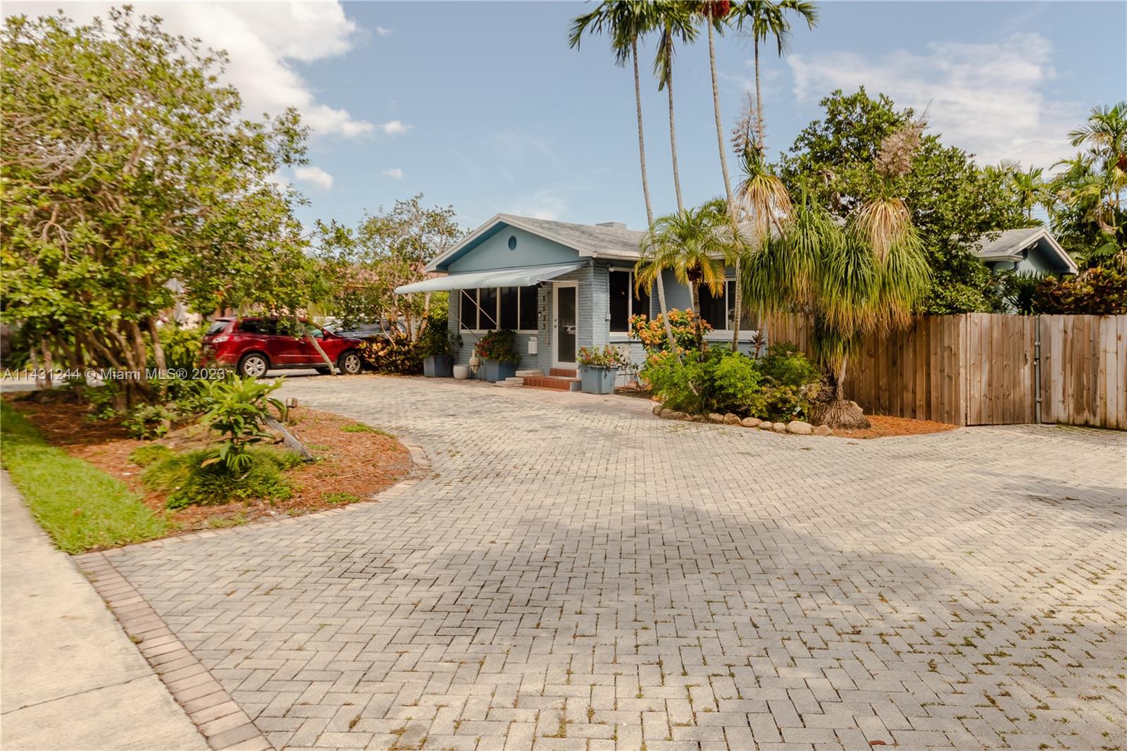 A light blue single-story house features a paved driveway and mature palm trees — 2533 Fillmore St, Hollywood FL 33020, HOLLYWOOD, FL