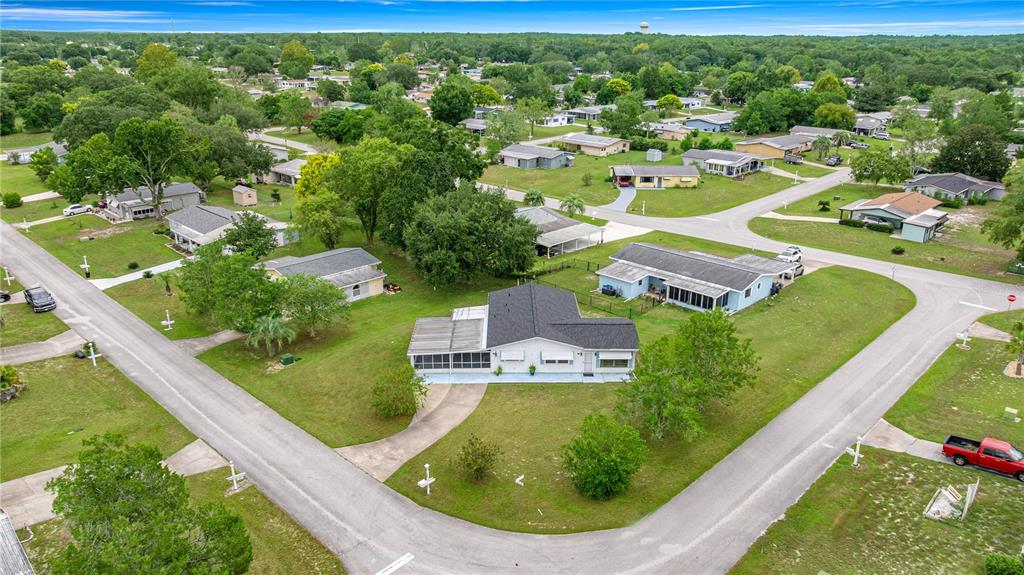 An aerial view shows a single-story house with a screened porch in a suburban neighborhood — 9230 SW 101ST LANE, OCALA, FL