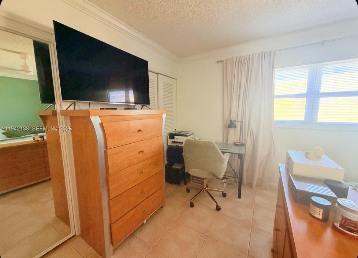 A bedroom features a large wooden dresser with a television, a desk, and a window — 420 NE 12th Ave # 502, Hallandale Beach FL 33009, HALLANDALE BEACH, FL