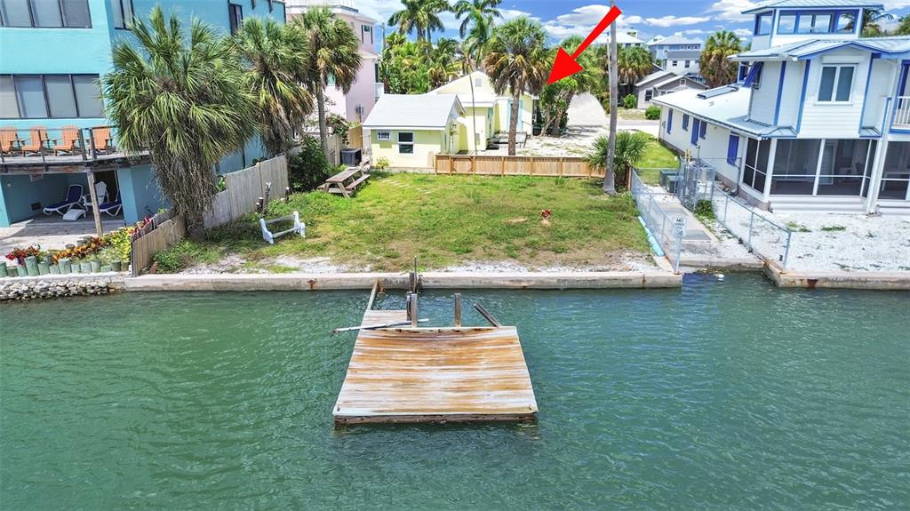 An aerial view of a waterfront property featuring a wooden dock and a small house — 201 90TH AVENUE, TREASURE ISLAND, FL