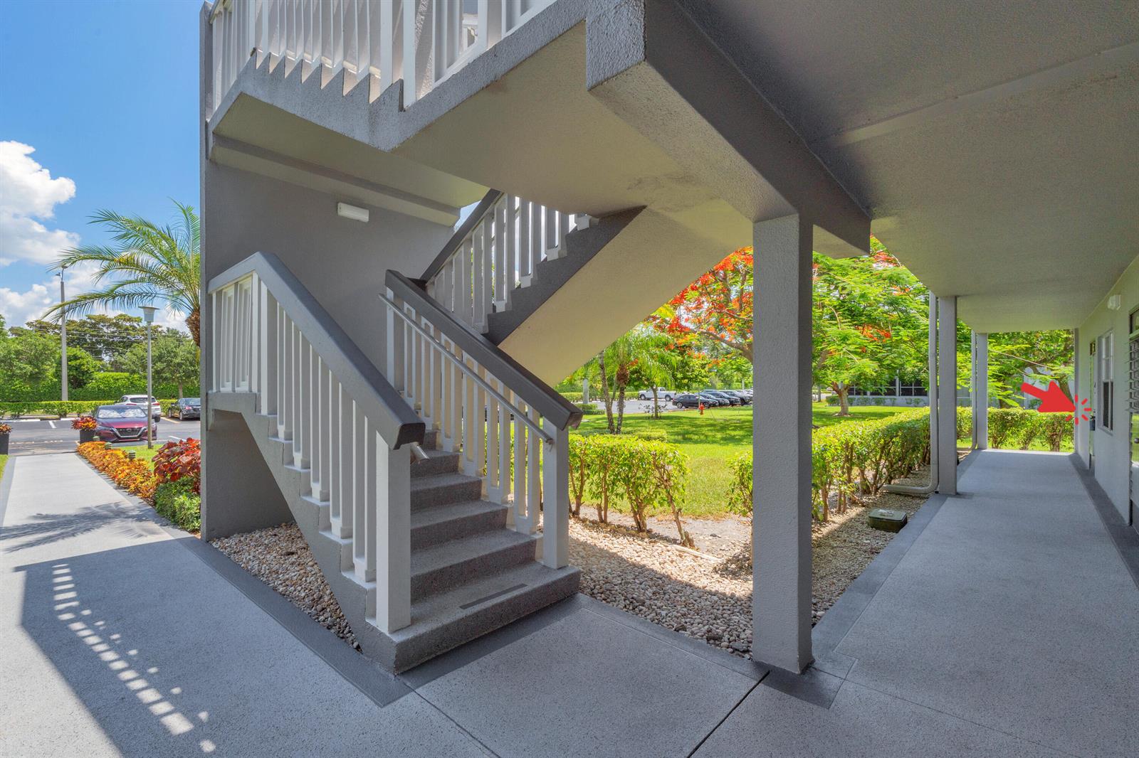 An outdoor staircase leads to a covered walkway with a door marked by a red arrow — 169 Suffolk E, Boca Raton FL 33434, BOCA RATON, FL
