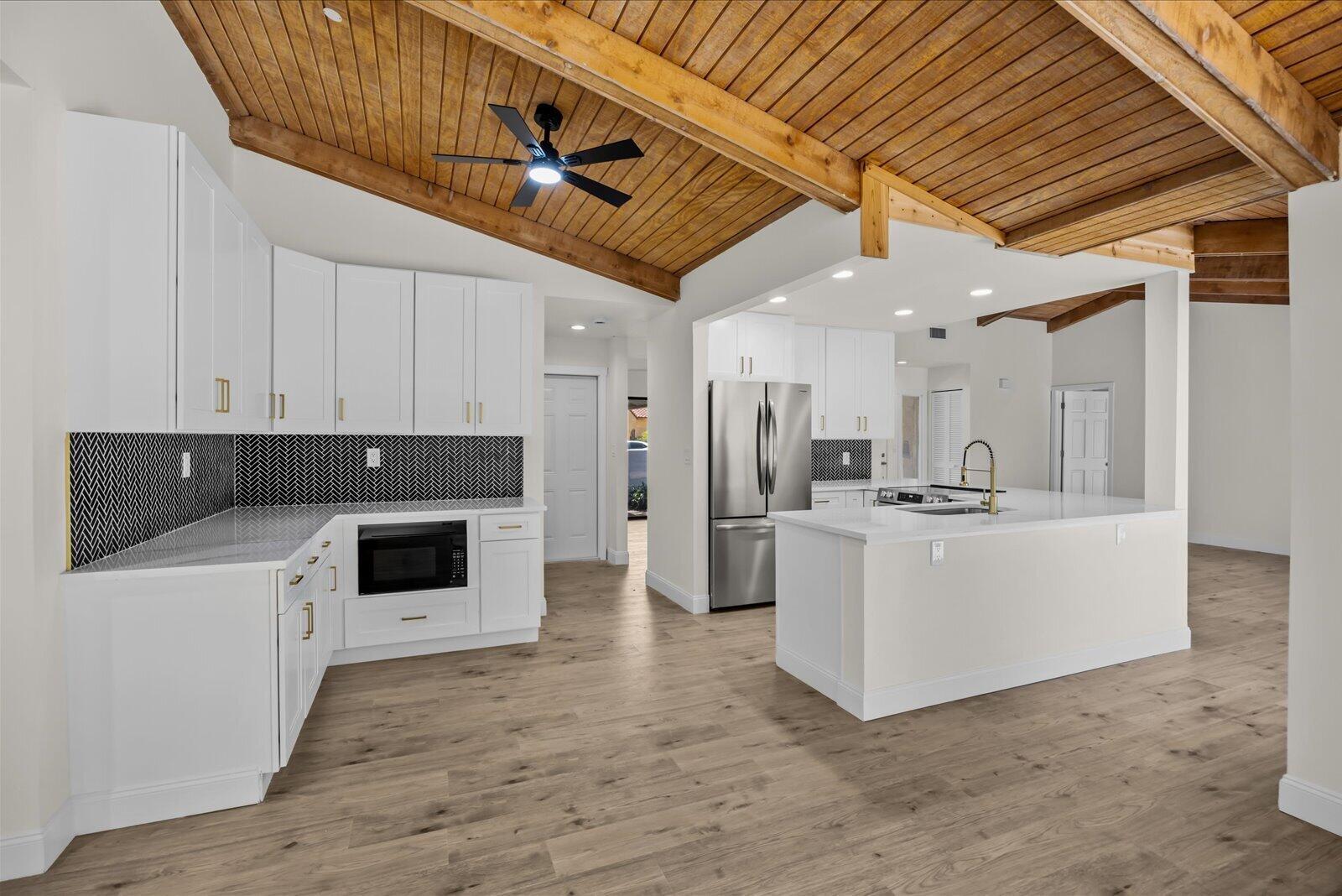 A kitchen with white cabinets, a herringbone backsplash, and a wood-paneled vaulted ceiling — 21143 N Escondido Way Way N, Boca Raton FL 33433, BOCA RATON, FL