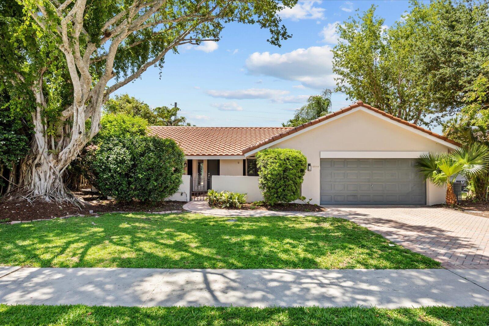 A single-story house with a tiled roof, a two-car garage, and a large tree — 21143 N Escondido Way Way N, Boca Raton FL 33433, BOCA RATON, FL
