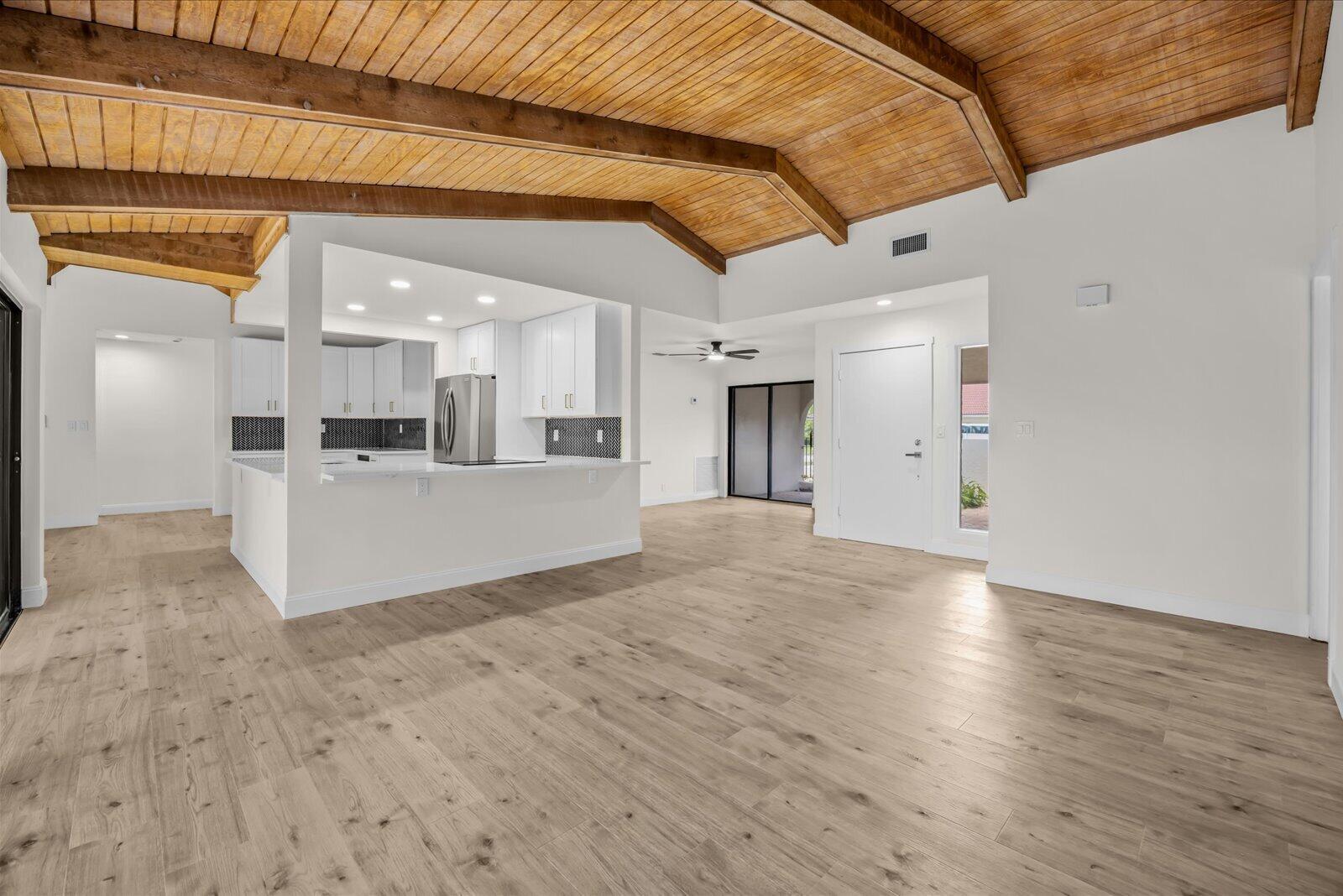 A bright, open-concept living area features light wood flooring and a vaulted wood-paneled ceiling — 21143 N Escondido Way Way N, Boca Raton FL 33433, BOCA RATON, FL