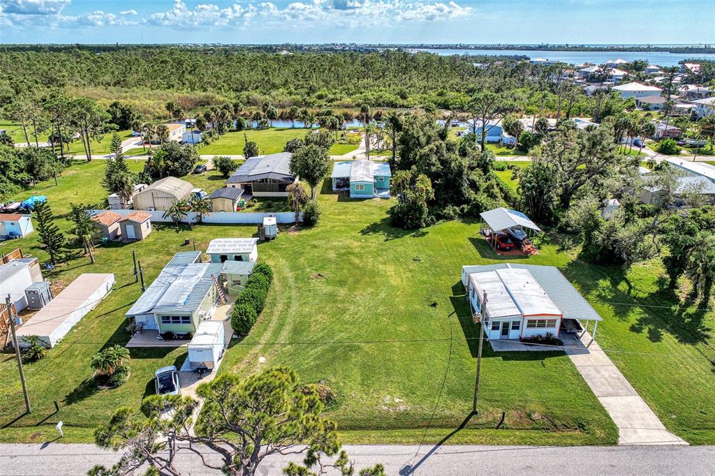 An aerial view shows two mobile homes on a large grassy lot with nearby trees — 8225 ROBERT STREET, ENGLEWOOD, FL