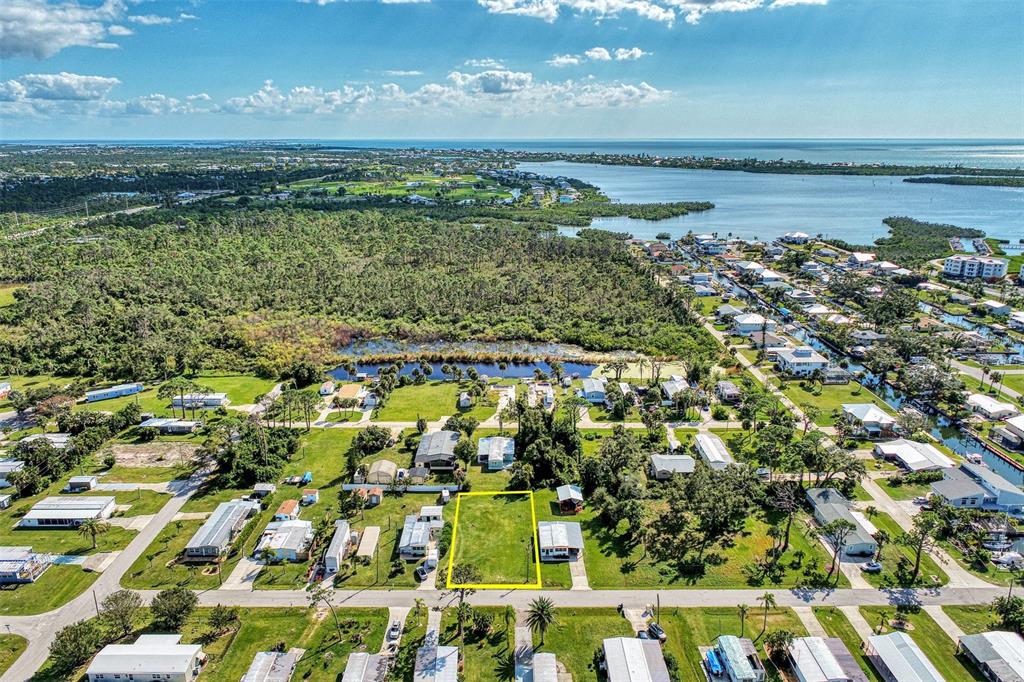 An aerial view shows a vacant rectangular lot outlined in yellow within a residential neighborhood — 8225 ROBERT STREET, ENGLEWOOD, FL