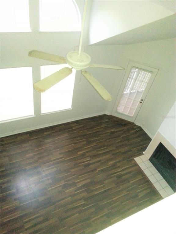A high-angle view of a living room with dark wood flooring, a ceiling fan, and fireplace — 6028 WESTGATE DRIVE UNIT 202, ORLANDO, FL