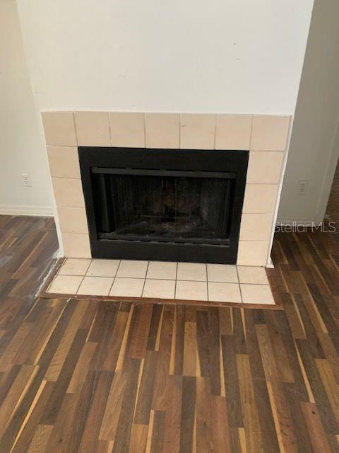 A fireplace with light-colored square tiles is centered against a wall above wood-look flooring — 6028 WESTGATE DRIVE UNIT 202, ORLANDO, FL