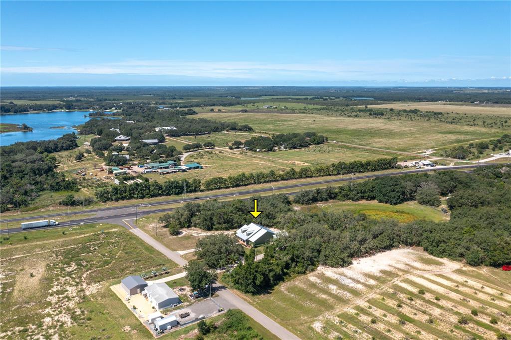 An aerial view shows a house surrounded by trees near a road and a lake — 35 STEMBRIDGE ROAD, LAKE WALES, FL