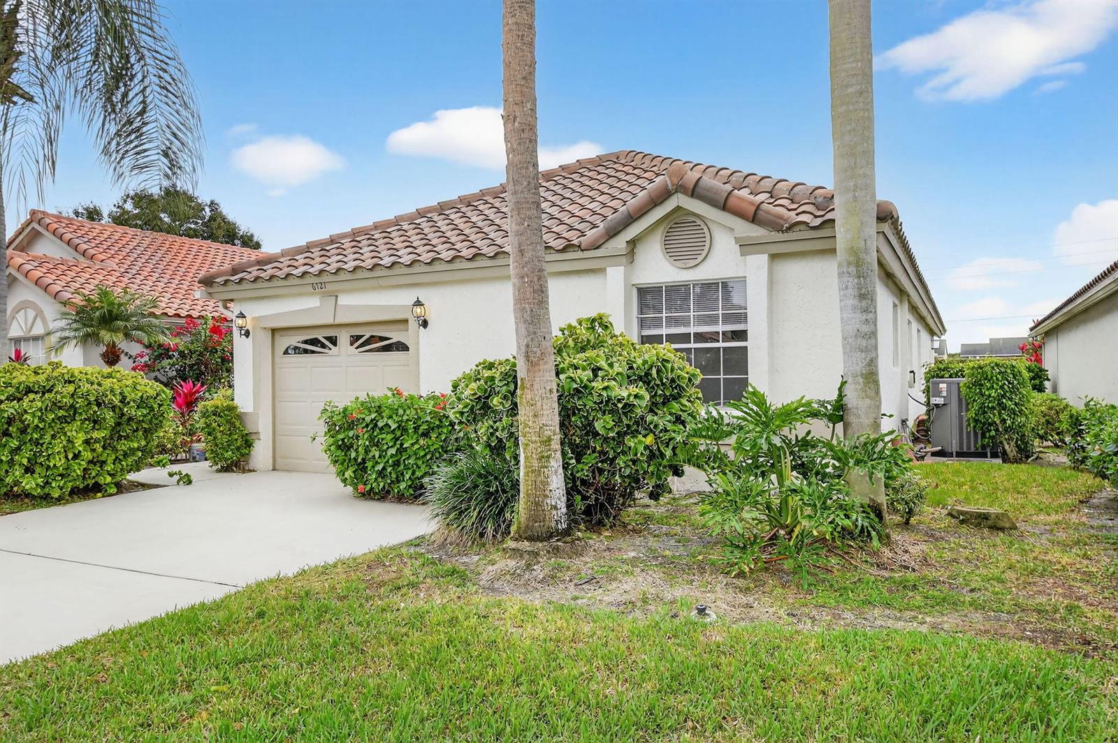 A single-story house with a tile roof, garage, and palm trees in the front yard — 6121 Bay Isles Drive, Boynton Beach FL 33437, BOYNTON BEACH, FL