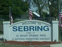 A white welcome sign for Sebring, Florida, stands outdoors with three American flags behind it — 8121 Armisha, FL 33870, FL