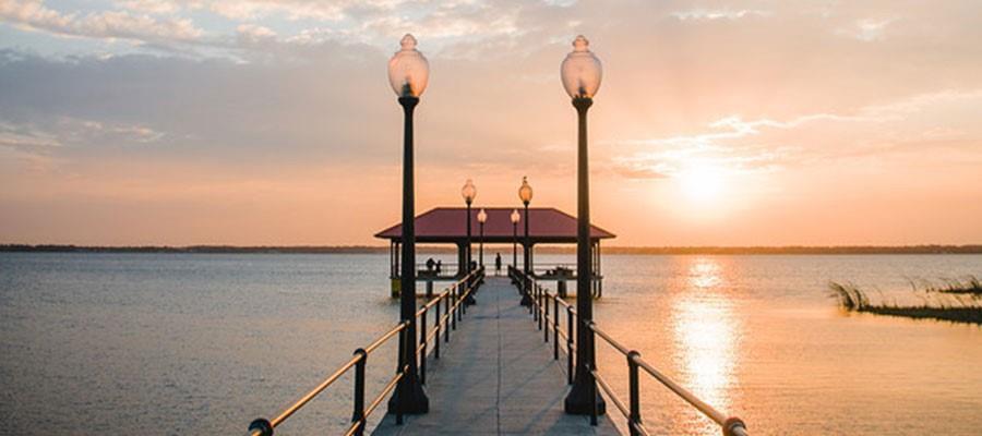 A long pier with lamp posts leads to a covered pavilion over a calm lake — 8121 Armisha, FL 33870, FL