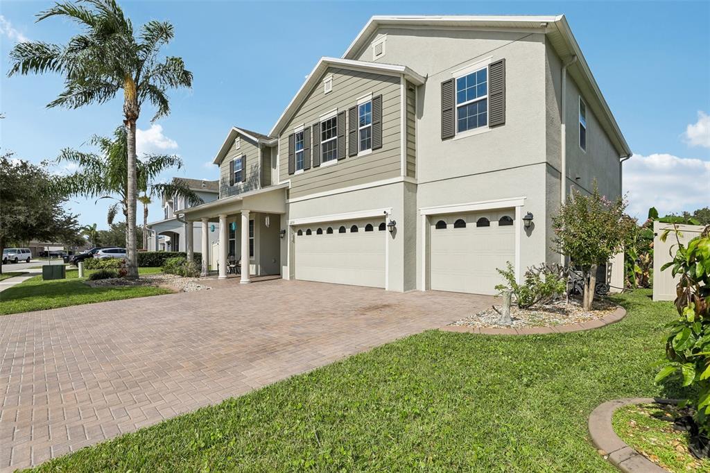 A two-story suburban house with a paved driveway, two garage doors, and a palm tree — 12255 STONE BARK TRAIL, ORLANDO, FL