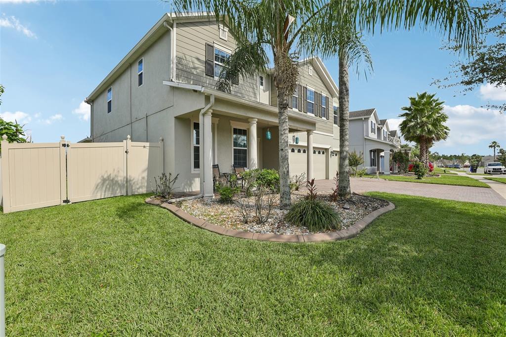 A two-story suburban house with a tan exterior, front porch, and a palm tree — 12255 STONE BARK TRAIL, ORLANDO, FL