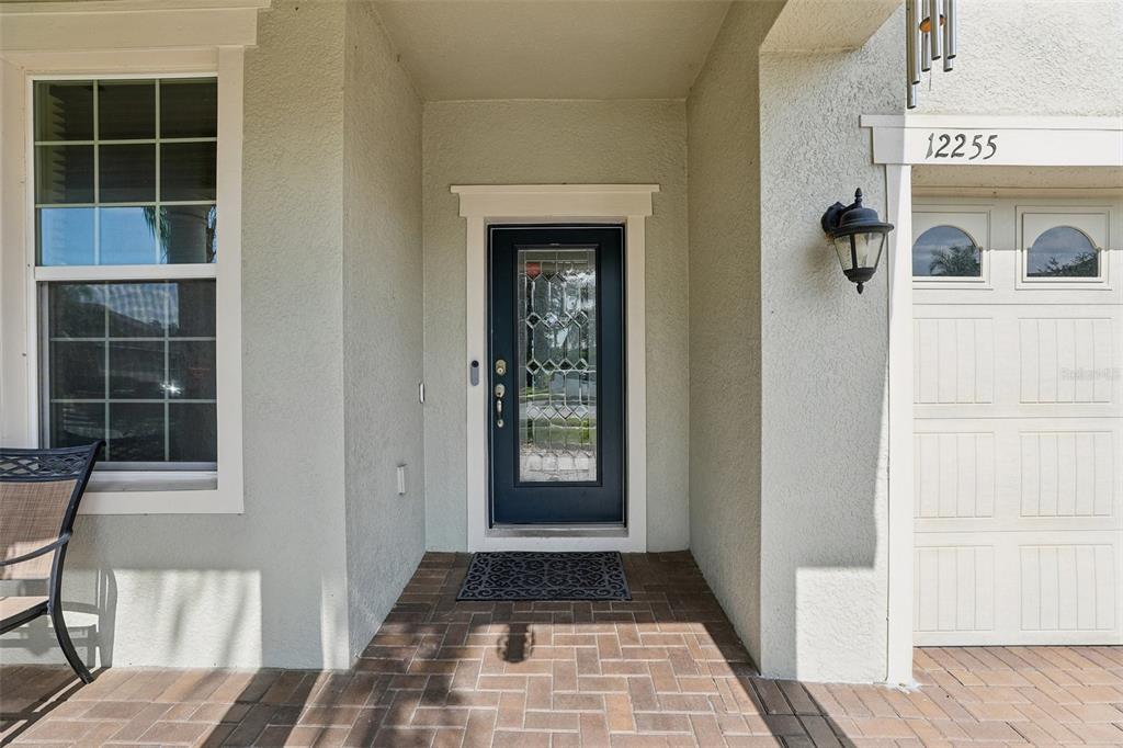 A front entryway features a dark door with glass panels, a brick porch, and garage — 12255 STONE BARK TRAIL, ORLANDO, FL