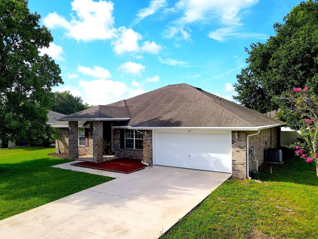 A single-story brick house with a two-car garage and a concrete driveway — 70 PHEASANT DRIVE, PALM COAST, FL