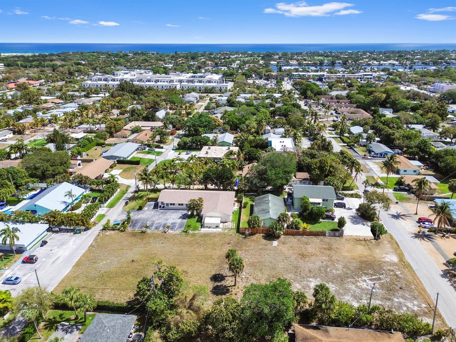 An aerial view shows a large, vacant rectangular lot situated between residential buildings and streets — 1955 Juno Road, North Palm Beach FL 33408, NORTH PALM BEACH, FL