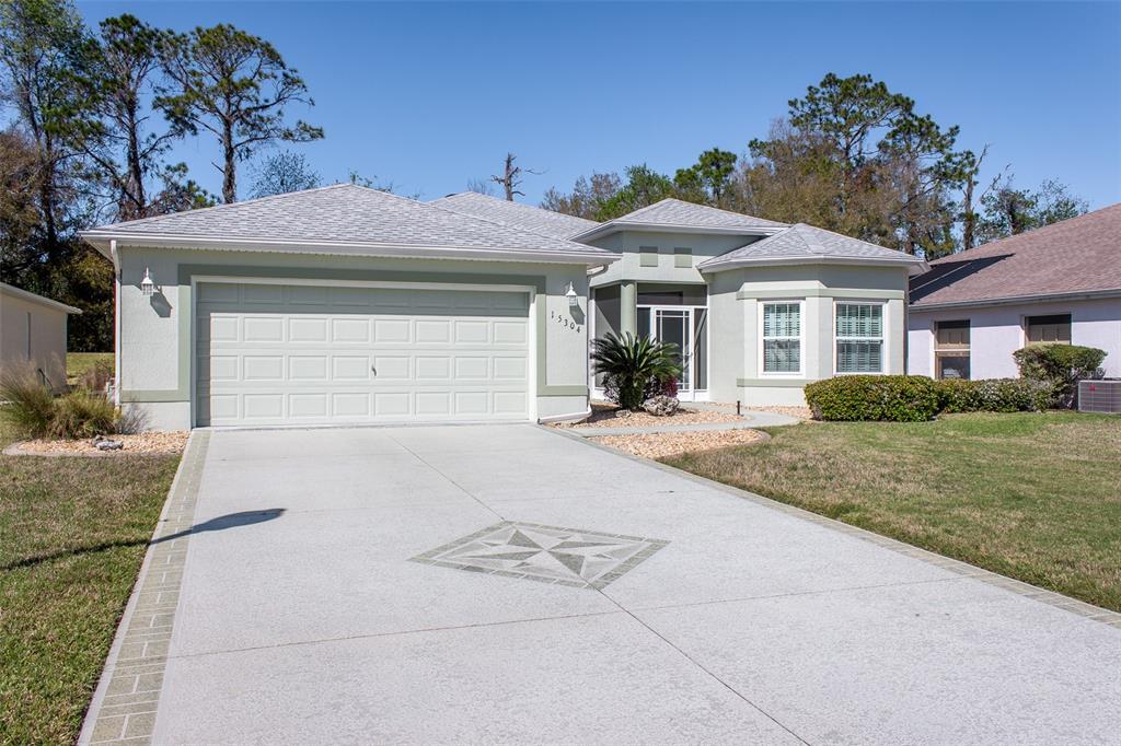 A single-story house features a two-car garage, a paved driveway, and a front entryway — 15304 SW 15TH TERRACE ROAD, OCALA, FL