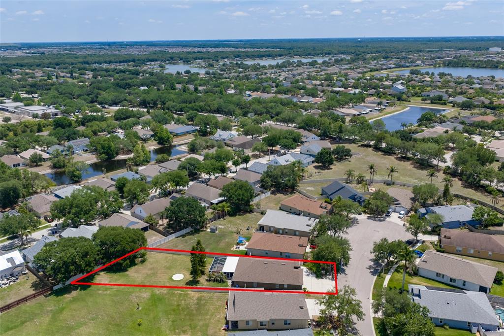An aerial view shows a single-family home with a large backyard enclosed by a fence — 7318 GUILFORD PINE LANE, APOLLO BEACH, FL