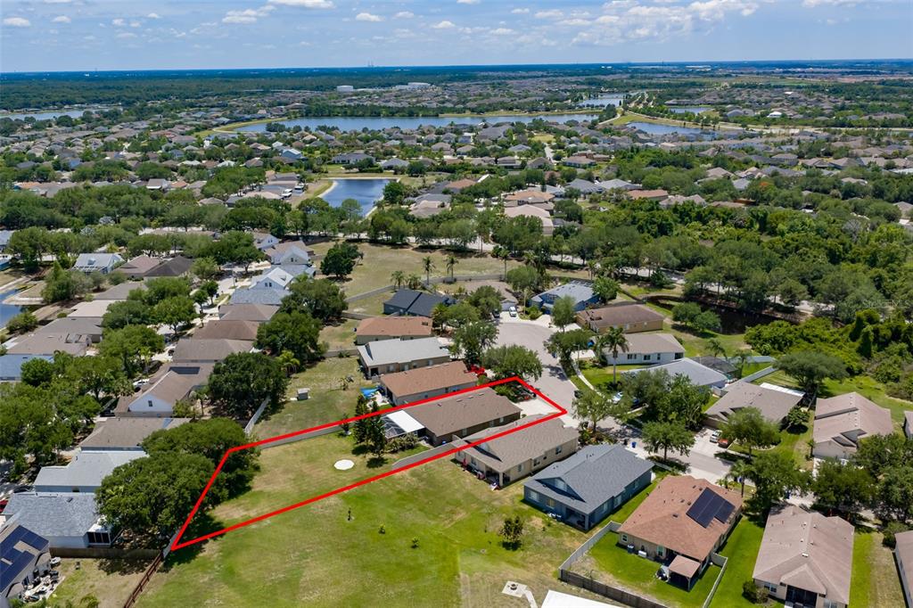 An aerial view shows a single-story house with a large backyard outlined in red — 7318 GUILFORD PINE LANE, APOLLO BEACH, FL