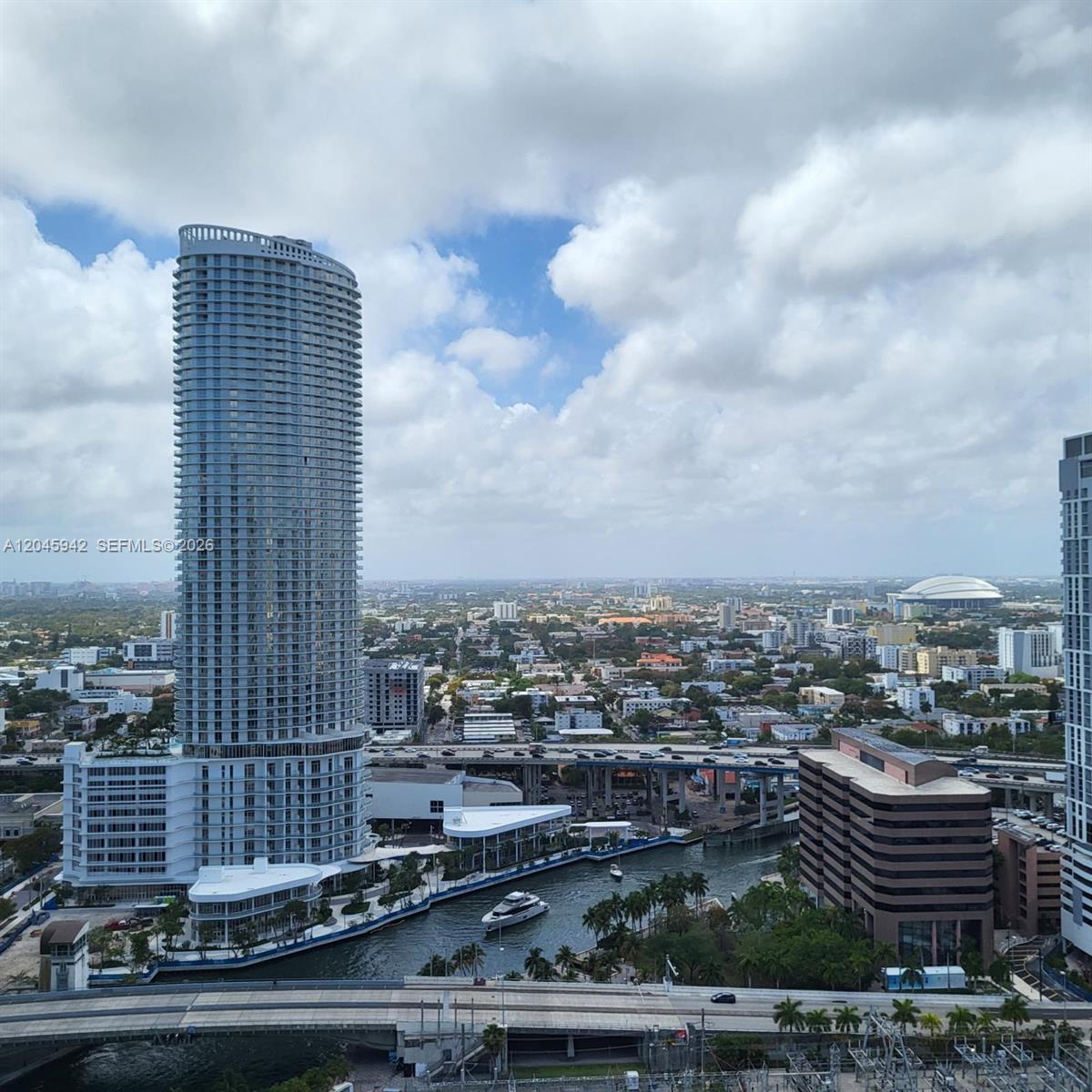 An elevated view shows a tall skyscraper, a river with a boat, and a highway — 92 SW 3rd St # 3207, Miami FL 33130, MIAMI, FL