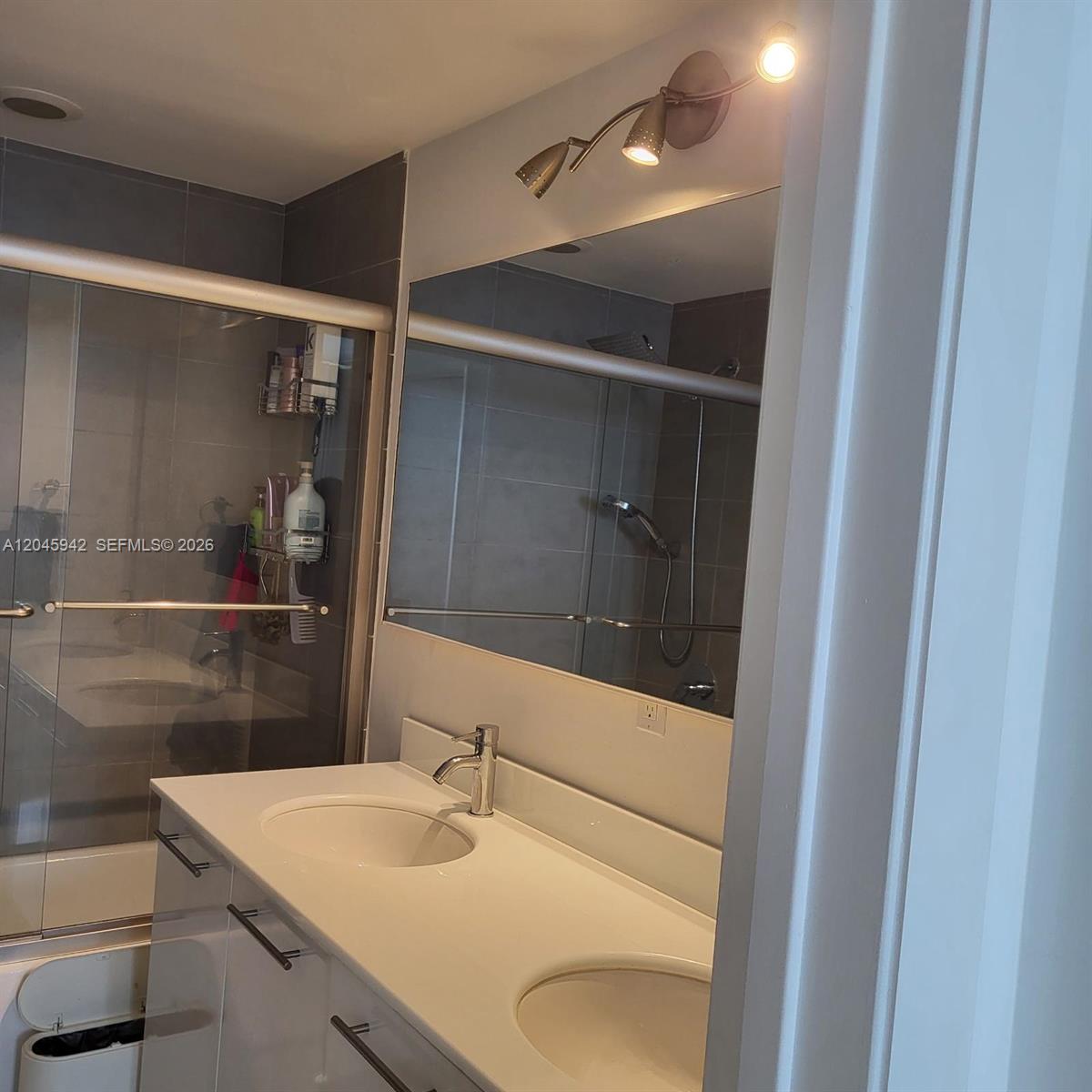 A bathroom features a double-sink vanity with white countertops and a large wall mirror — 92 SW 3rd St # 3207, Miami FL 33130, MIAMI, FL