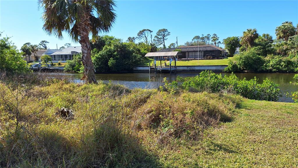 A view of a canal with a boat dock and houses in the background — 3173 ROCK CREEK DRIVE, PORT CHARLOTTE, FL