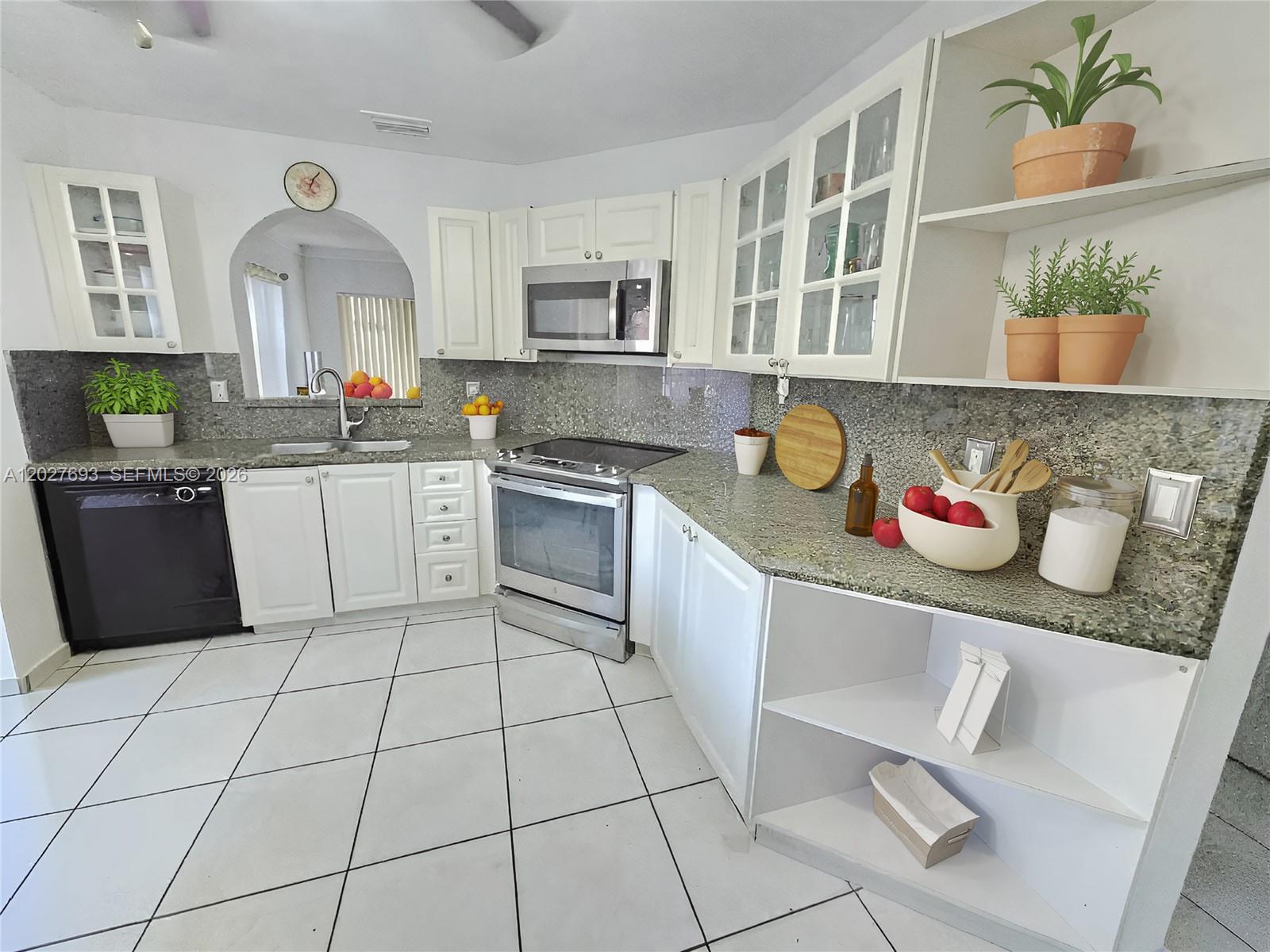 A kitchen features white cabinets, granite countertops, stainless steel appliances, and white tile flooring — 7255 NW 173rd Dr # 8, Hialeah FL 33015, HIALEAH, FL