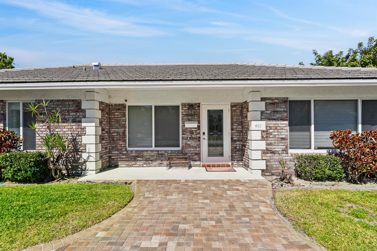 A single-story brick house features a paved walkway leading to a white-framed glass front door — 401 NE 10th Terrace, Boca Raton FL 33432, BOCA RATON, FL