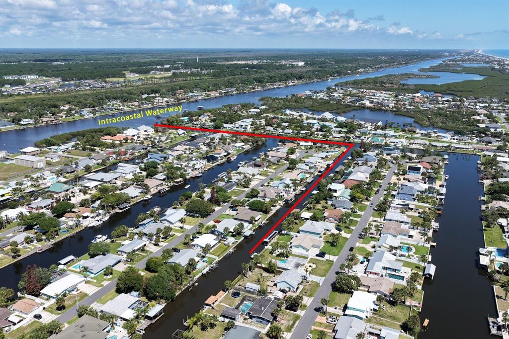 An aerial view shows a residential neighborhood with canals leading to the Intracoastal Waterway — 119 N PALMETTO AVENUE, FLAGLER BEACH, FL