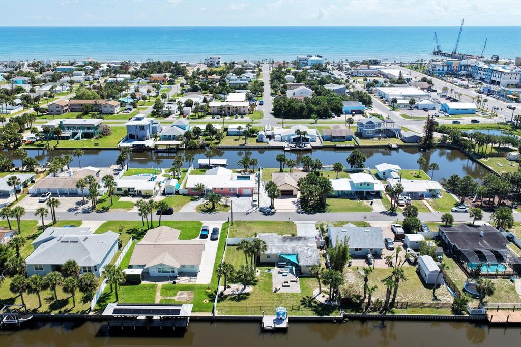 An aerial view of a coastal neighborhood with houses, a canal, and the ocean beyond — 119 N PALMETTO AVENUE, FLAGLER BEACH, FL