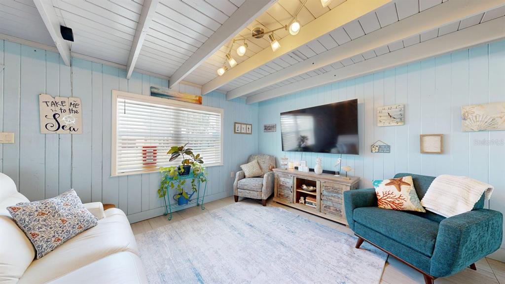 A living room features light blue paneled walls, a white vaulted ceiling, and coastal decor — 119 N PALMETTO AVENUE, FLAGLER BEACH, FL