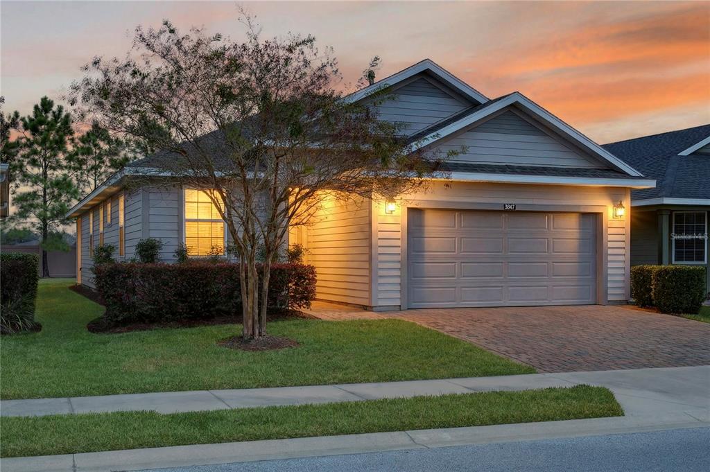 A single-story house with gray siding, a two-car garage, and a paved driveway at sunset — 3947 NW 46TH TERRACE, OCALA, FL
