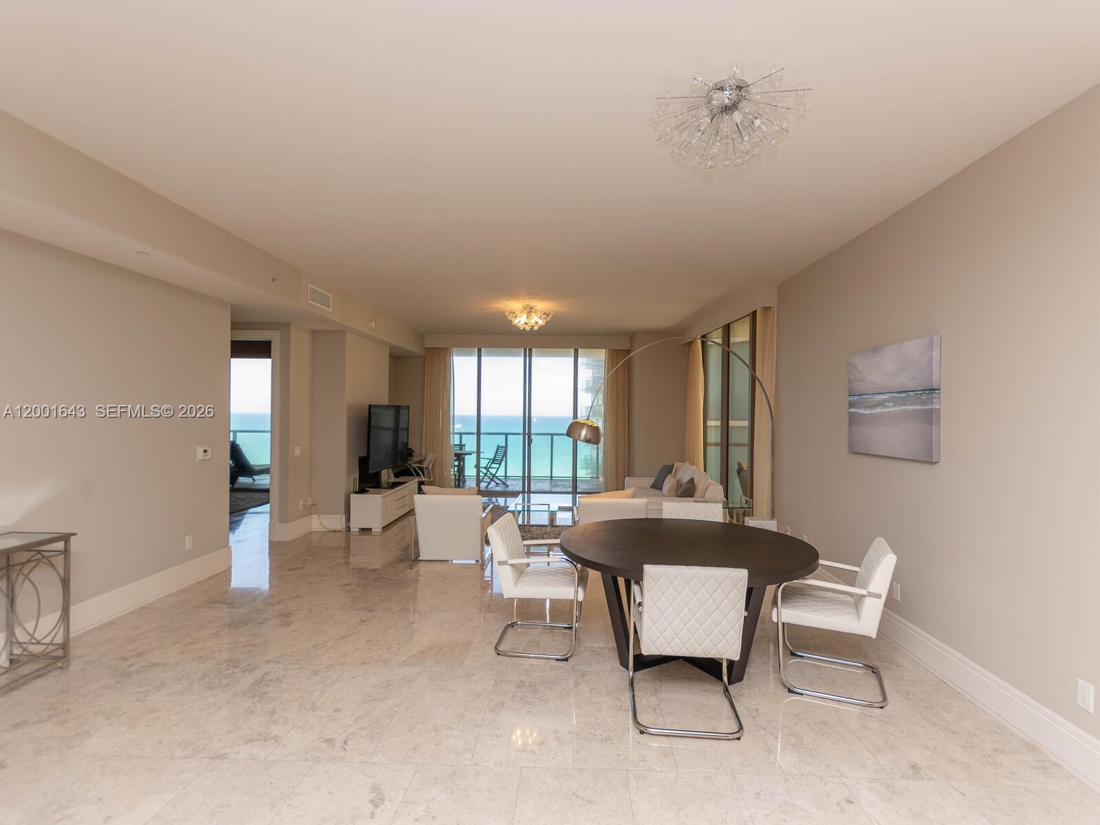 A dining area and living room with marble floors overlook the ocean through glass doors — 9705 Collins Ave # 804N, Bal Harbour FL 33154, BAL HARBOUR, FL