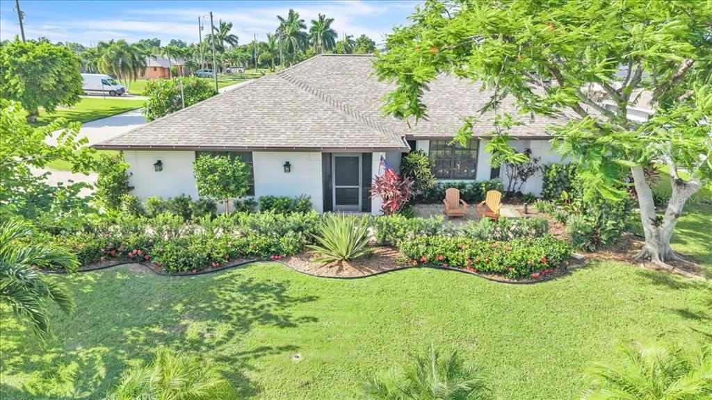 A single-story house with a white exterior, shingled roof, and landscaped front yard — 1903 SE 29TH LANE, CAPE CORAL, FL